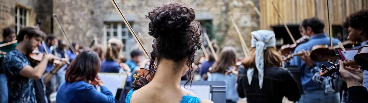 Un orchestre de violon performe devant une foule