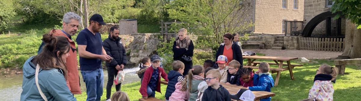 Un groupe d'enfants en visite le Moulin et profite d'un temps en extérieur autours d'une table de pique-nique