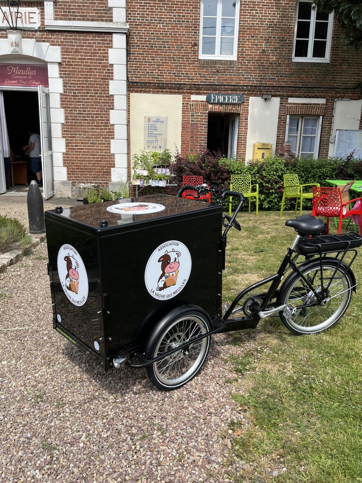 Le vélo de livraison de "La Vache qui Meulles" devant l'entrée de l'épicerie