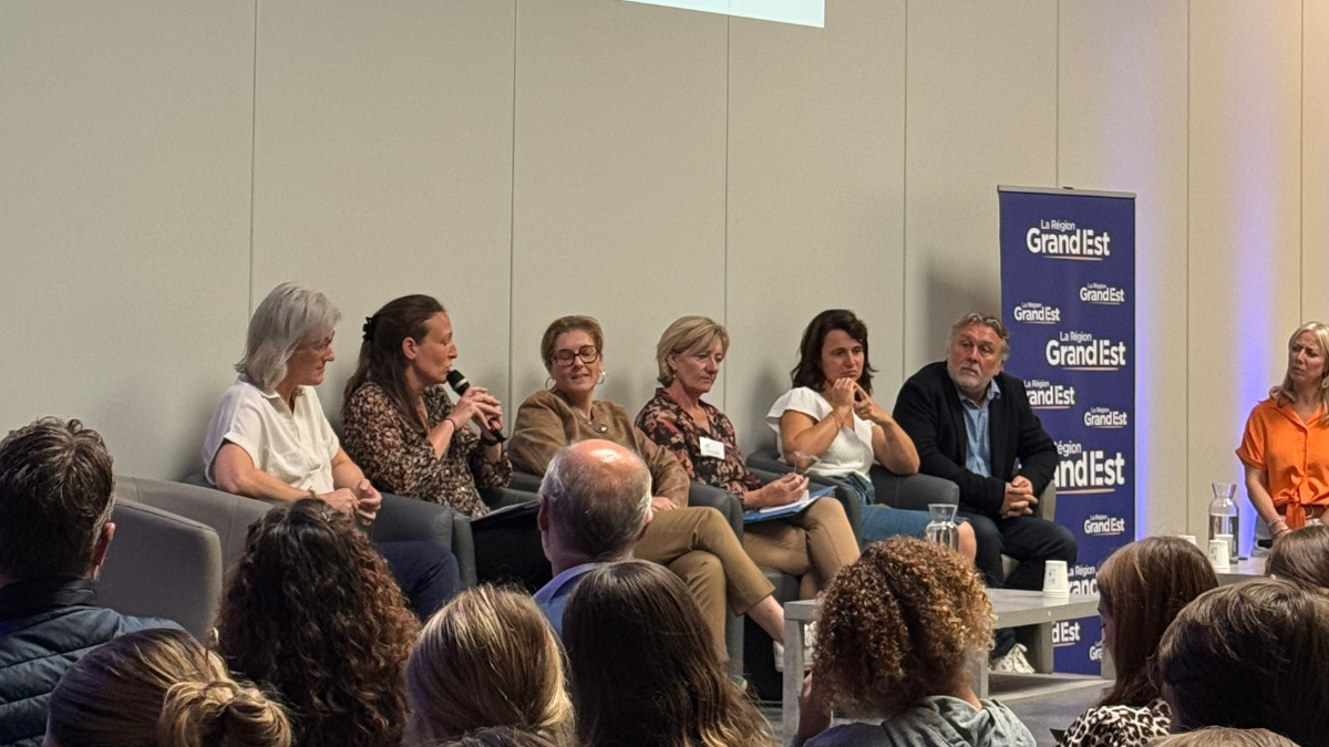 Photo des intervenants de la conférence, sur une estrade, face au public