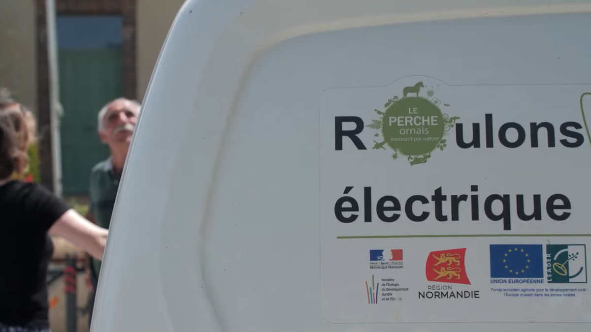 Arrière d'un véhicule électrique de Longny-les-villages, floqué : Perche Ornais, Région Normandie et programme LEADER