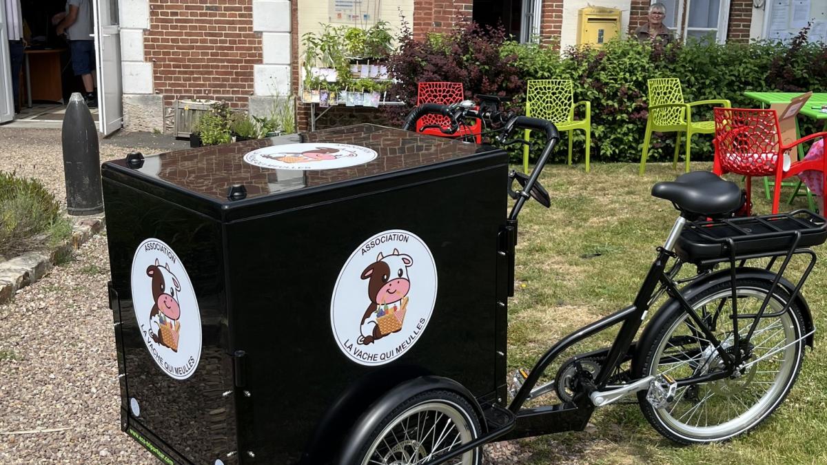 Le vélo de livraison de "La Vache qui Meulles" devant l'entrée de l'épicerie